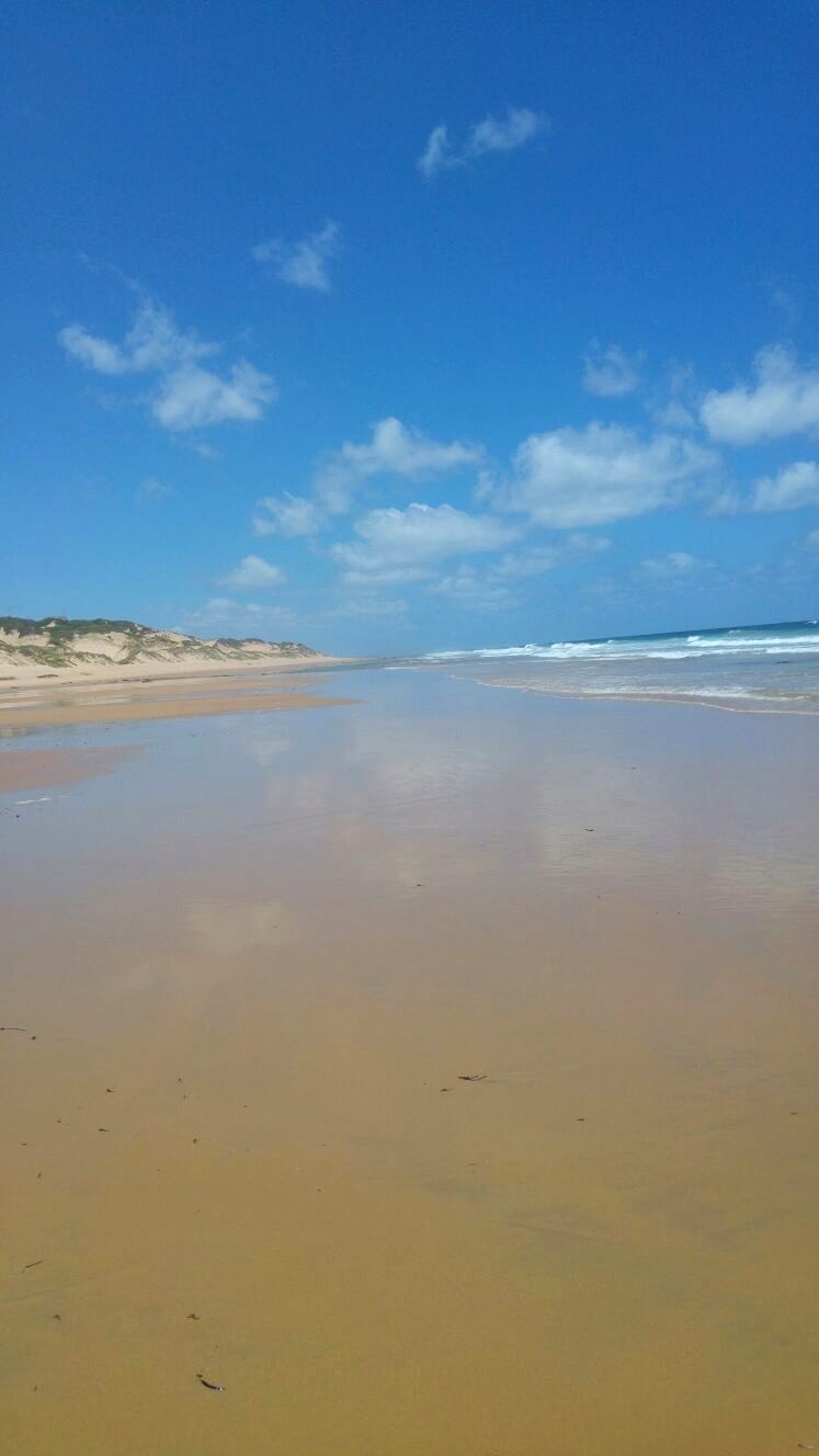 Wet sand mirroring the sky on the beach